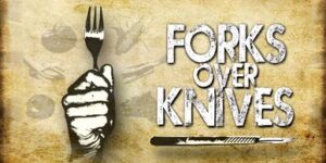 Forks Over Knives film poster, showing a hand gripping a fork.