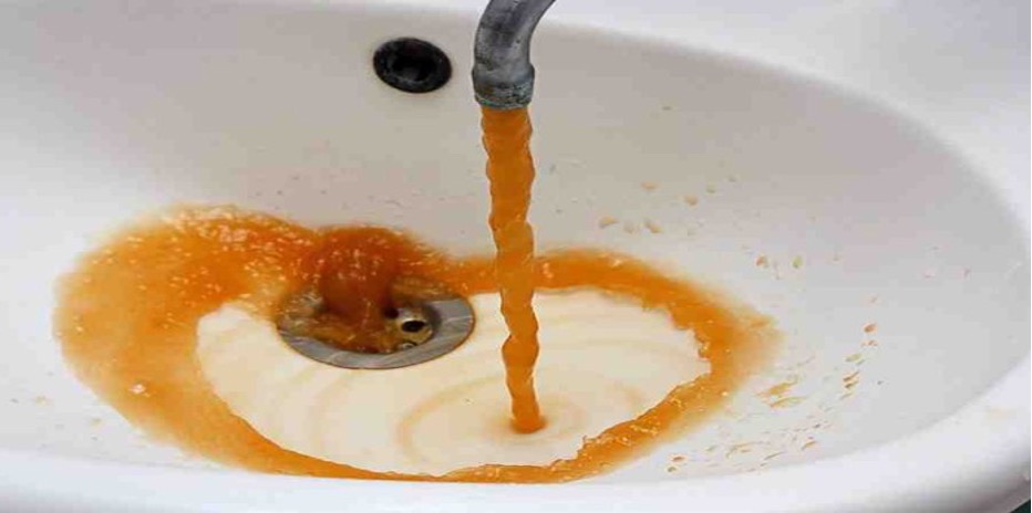 Brown water pouring out of a sink faucet in the Flint Water Crisis.