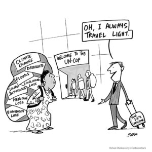 Comic showing a line of people carrying their baggage into the UN-COP. A white man carrying a little bag labeled "The 1-5 degree challenge" says to a woman of color carrying a very large bag "Oh, I always travel light." The woman's bag has the labels "climate change," "droughts," "social injustices," and a number of other global issues.