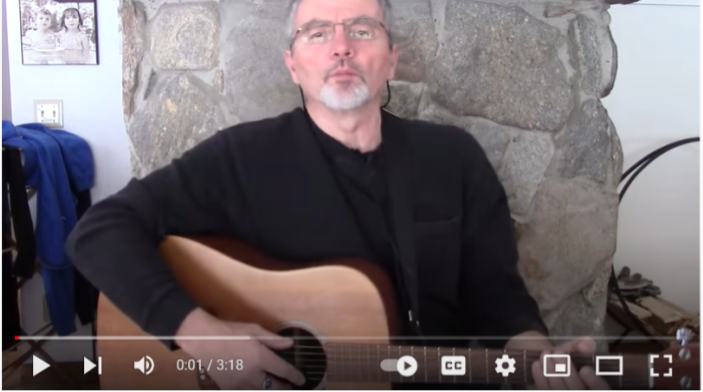Rabbi Joe Laur performing with his guitar in a youtube video.